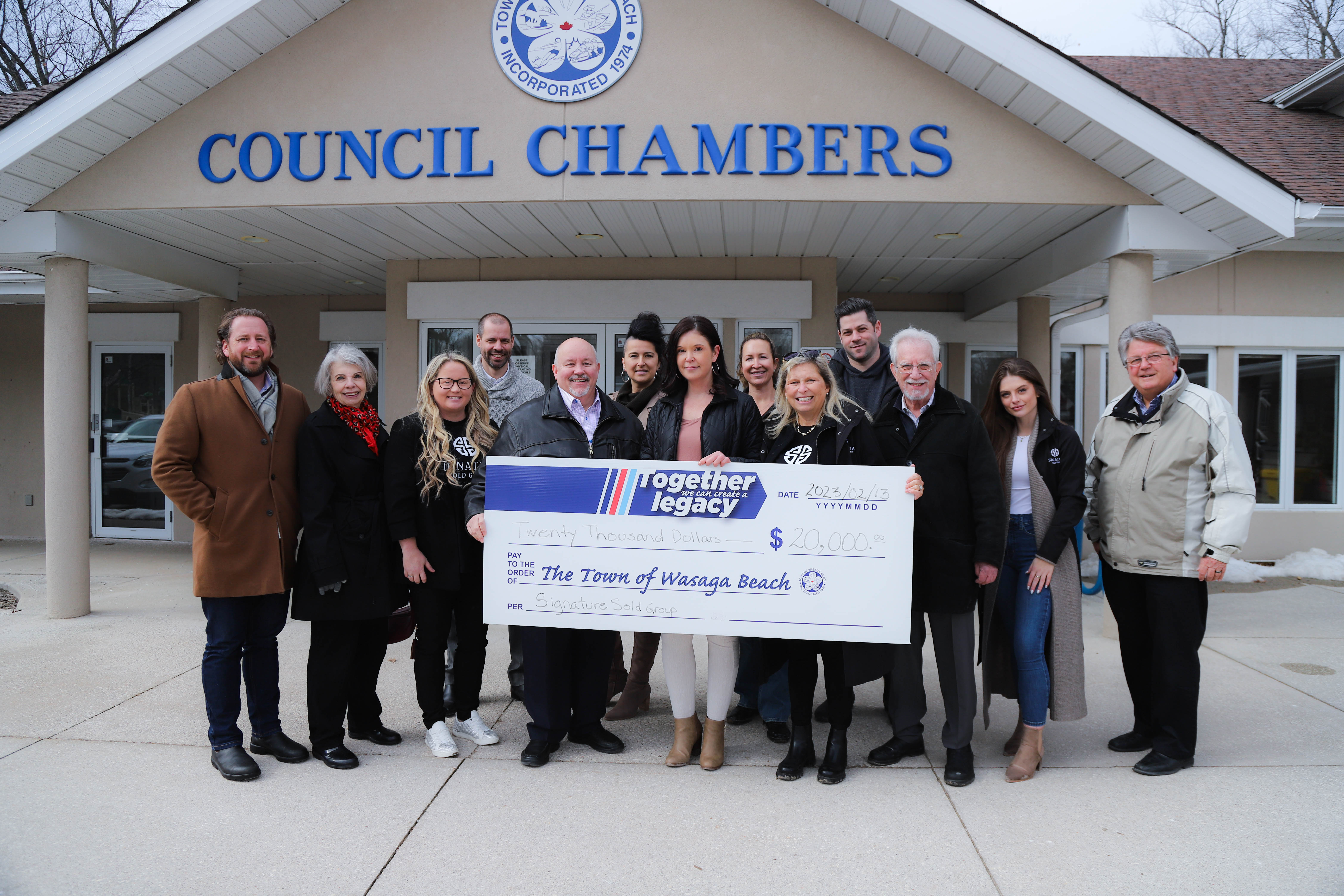 An image of Signature Group along with Mayor Brian accepting the donation check